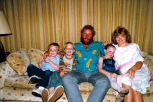 Brenna McKinnon as a child on grandparent's couch with parents and brothers 