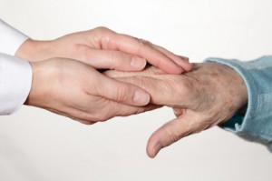 young female hands clasping an older man's hands