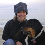 jodie dalton in cap with dog on beach