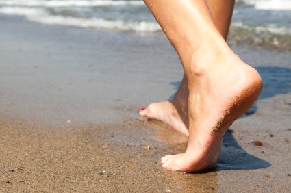 Woman's feet digging in sand as she's walking forward