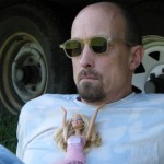 jim gray with barbie doll on his chest