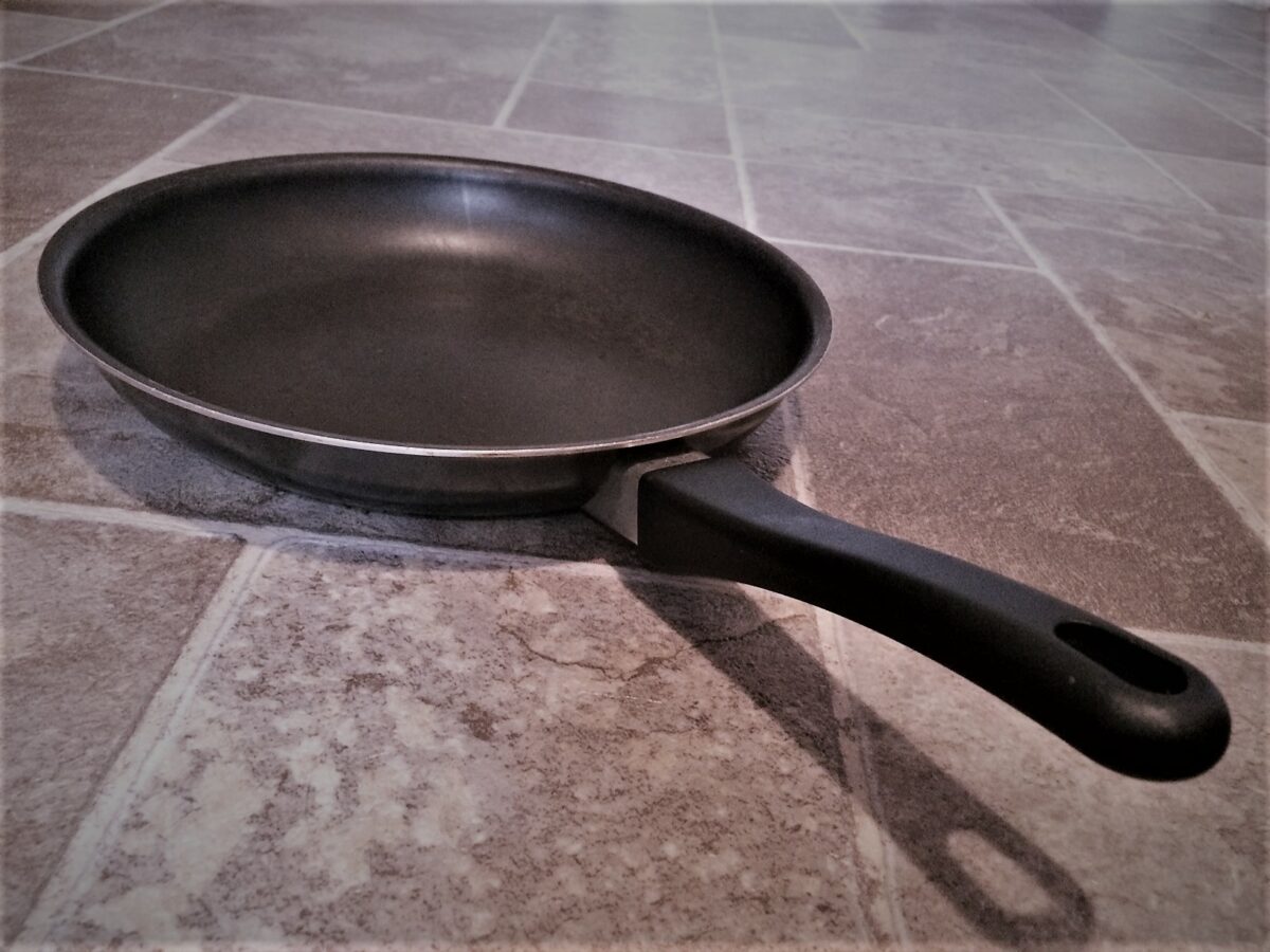 frying pan in middle of kitchen floor