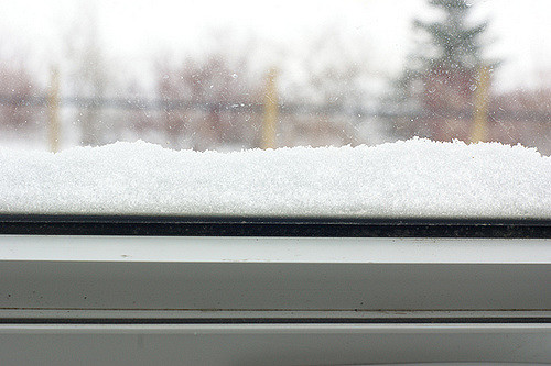Window looking out with snow piled on the sill