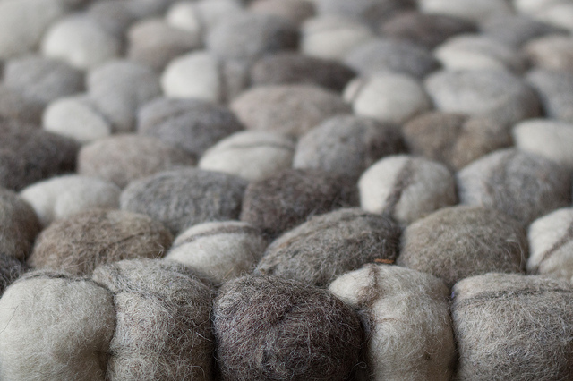 Close up shot of small cotton wool balls in gray and offwhite