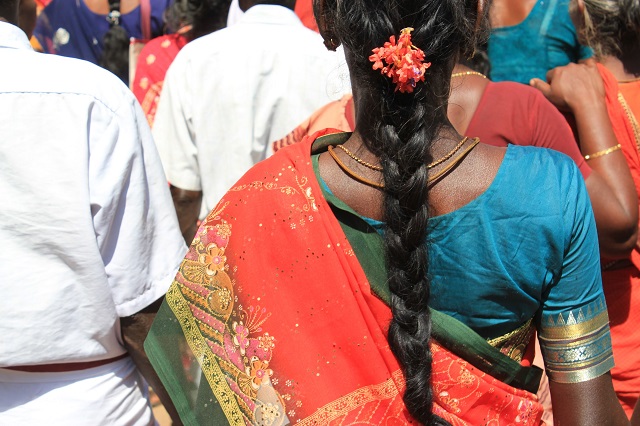 Close up of indian woman in crowd with focus on her long braid
