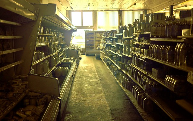 inside a small, older grocery store looking down a dingy aisle