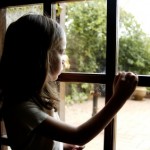 young girl looking out window
