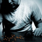 Depressed man at tables with pills