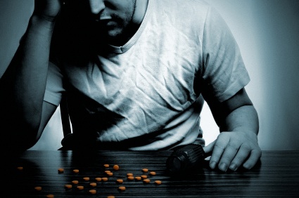 Depressed man at tables with pills