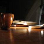 coffee lit cigarette and book on dark background to signify early morning