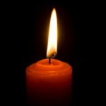 lit candle in dark room