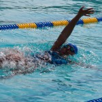 african american young woman in pool doing backstroke