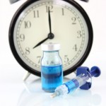 clock with bottle and syringe to signify waiting for a cure