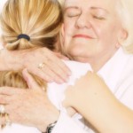granmotherly woman hugging young child with ponytail