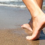 woman's feet digging in sand as she's walking forward