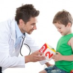 young male pediatrician with boy holding block