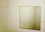 small square mirror in tiled bathroom