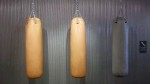 three-punching-bags along an old wall