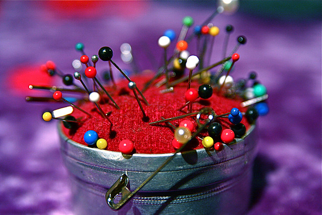 different color pins on a pin cushion