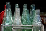 old coke bottles in recycling crate