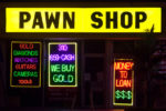 exterior of pawn shop neon lights advertising cash for things