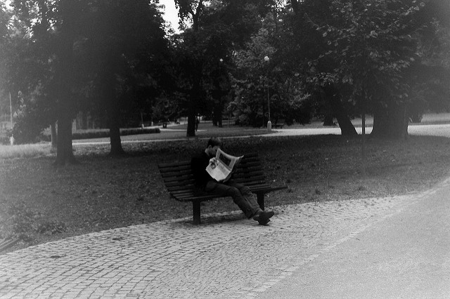 man reading paper in park