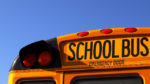 school bus back, close up of top against bright blue sky