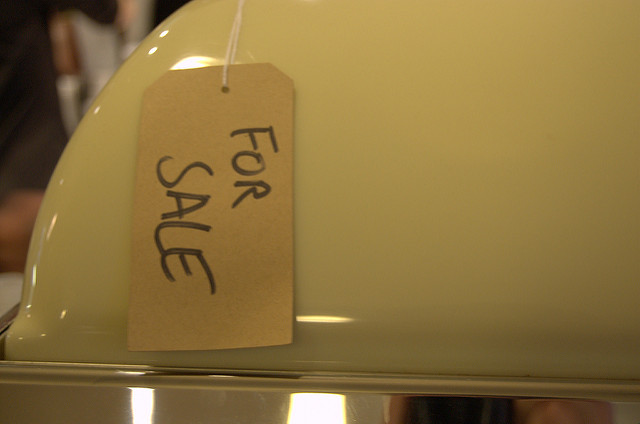 close up of "for sale" tag on a shiny white appliance