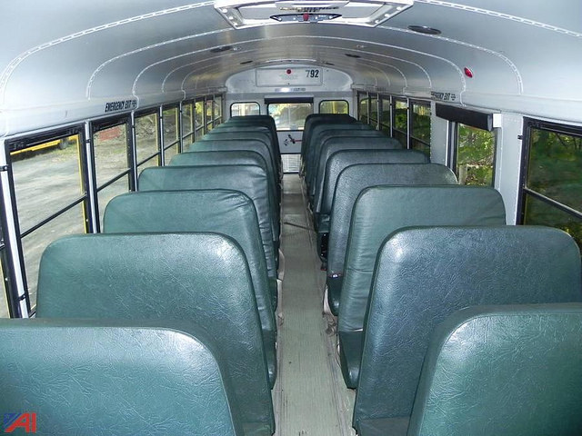emtpy school bus showing older green seats
