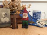various keepsakes om table: garden gnome, old photo, mug, etc.