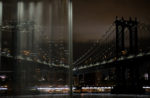 image of manhattan bridge out of a window, with a reflection of the bridge in the other half of the window - at night with lights