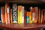 book shelf full of spanish language reference books such as a dictionary and book of verbs