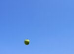 apple falling from sky - bright, blue, cloudless sky - image a symbol of gravity pulling