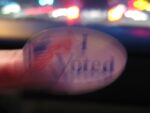 blurry i voted sticker with city lights in back