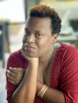 Headshot of Cija Jefferson, a Black woman, wearing a red shirt and gold bracelet.