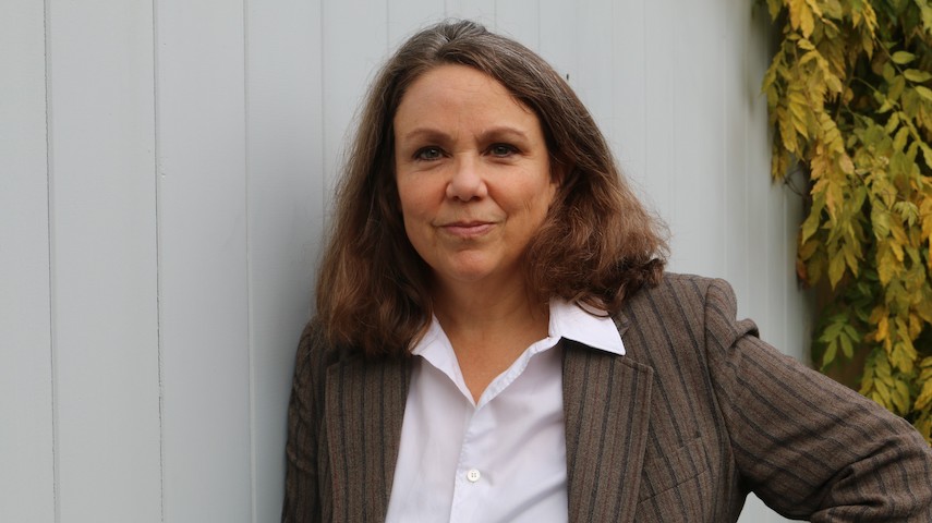 Headshot of author Debora Harding. The author wears a brown blazer and white shirt.