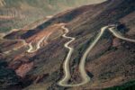 curvy, mountanous road in a desert; aerial shot from above; image you'd likely see in a car commercial