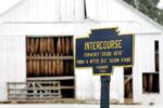 official village sign for "Intercourse PA" in front of barn - sign says, "Formerly Cross Keys' Founded 1754
