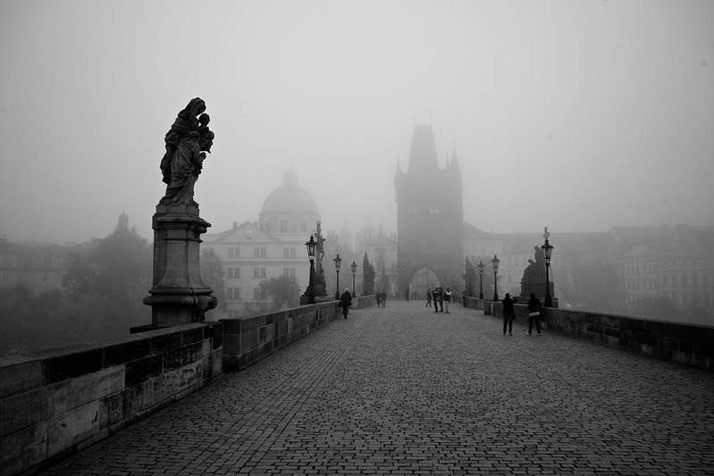 empty stone bridge in prague with statues; foggy day