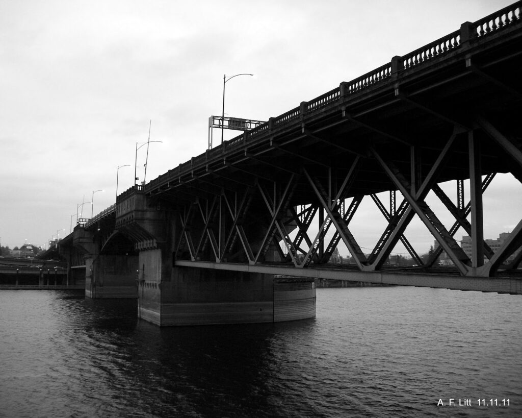 black and white image look up at the Burnside Bridge which shows steel tressel beneath