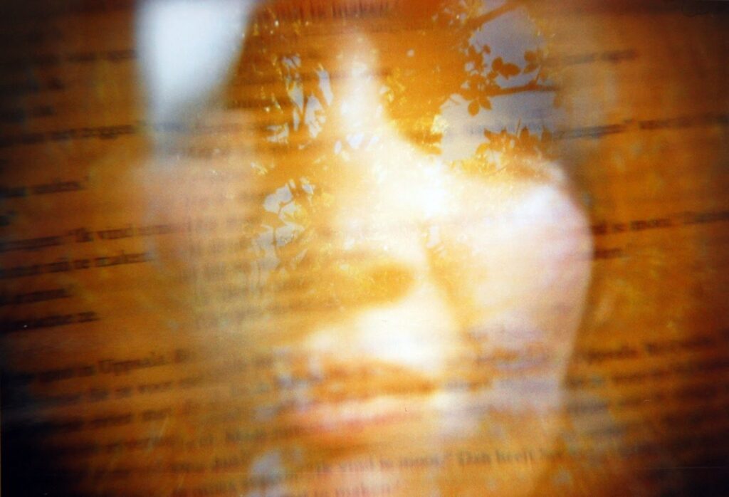Woman's face with tree and book reflection