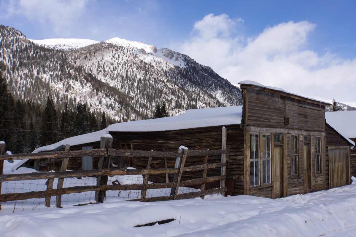 cabin at the foot of a snowy mountain