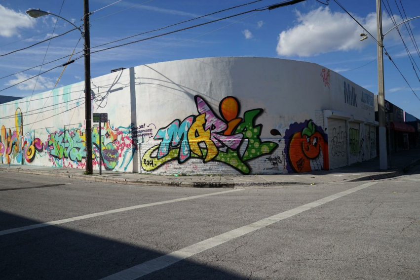 warehouse on street corner covered in colorful street art