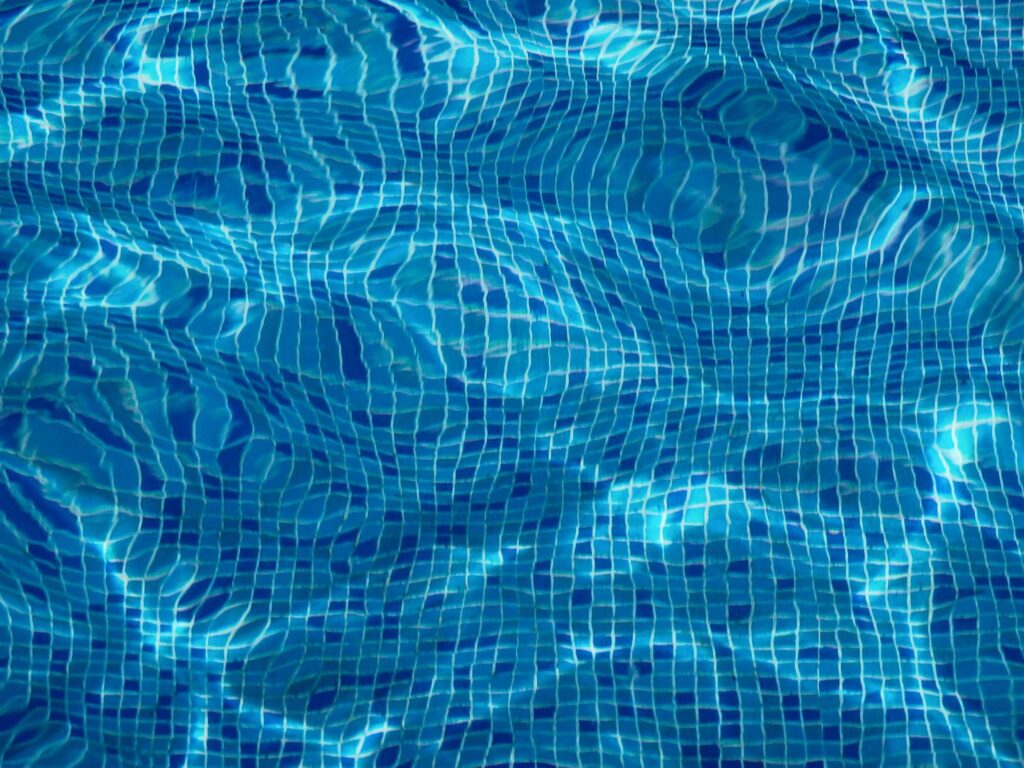 Swimming pool close up of water and blue tile floor