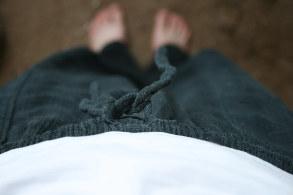 View of person wearing sweatpants looking down at their feet