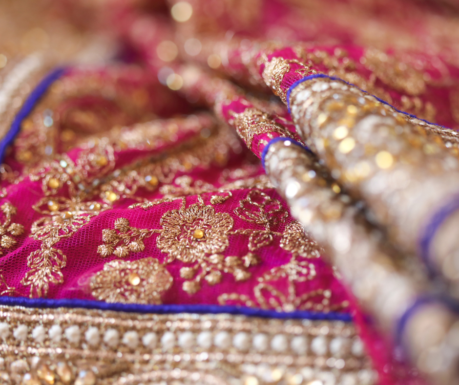 Close up detail of saree fabric and embroidery flecks of gold
