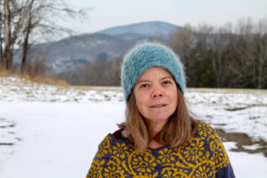 Brett Ann Stanciu in snow-covered field wearing fuzzy hat