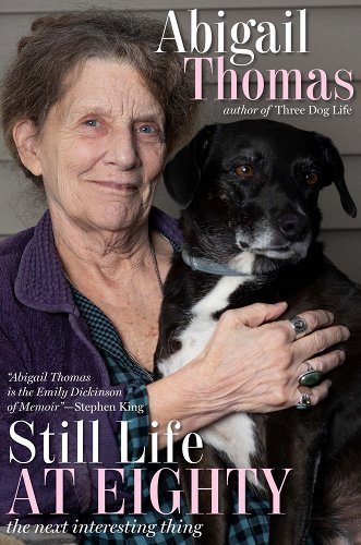 A picture of a woman with her black and white dog is seen above the title still life at eighty by abigail thomas