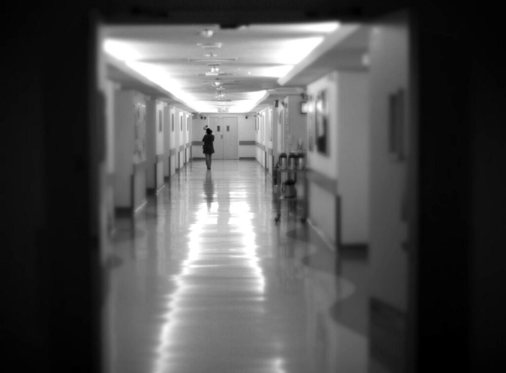Long hospital hallway with shiny clean floors person just out of frame