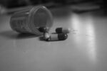 prescription bottled laying on its side with capsule pills falling out
